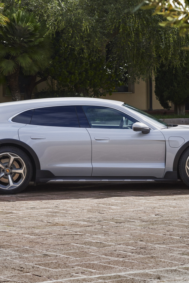 Серебристый автомобиль Porsche Taycan 4S Cross Turismo 2021 года у дома