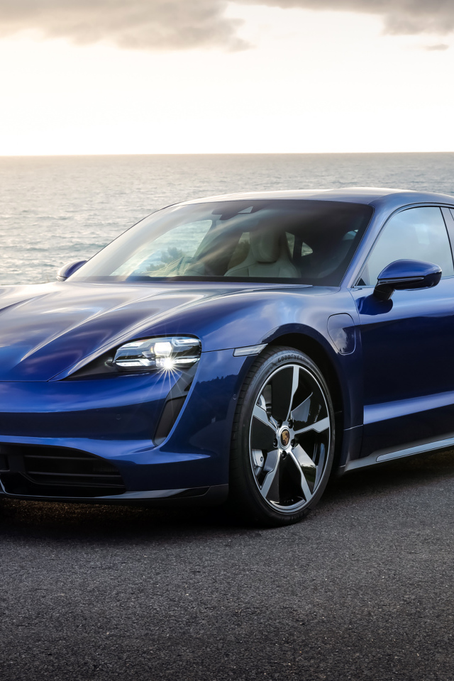 Синий автомобиль Porsche Taycan Turbo у моря