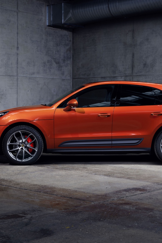 Оранжевый Porsche Macan S 2021  года на сером фоне