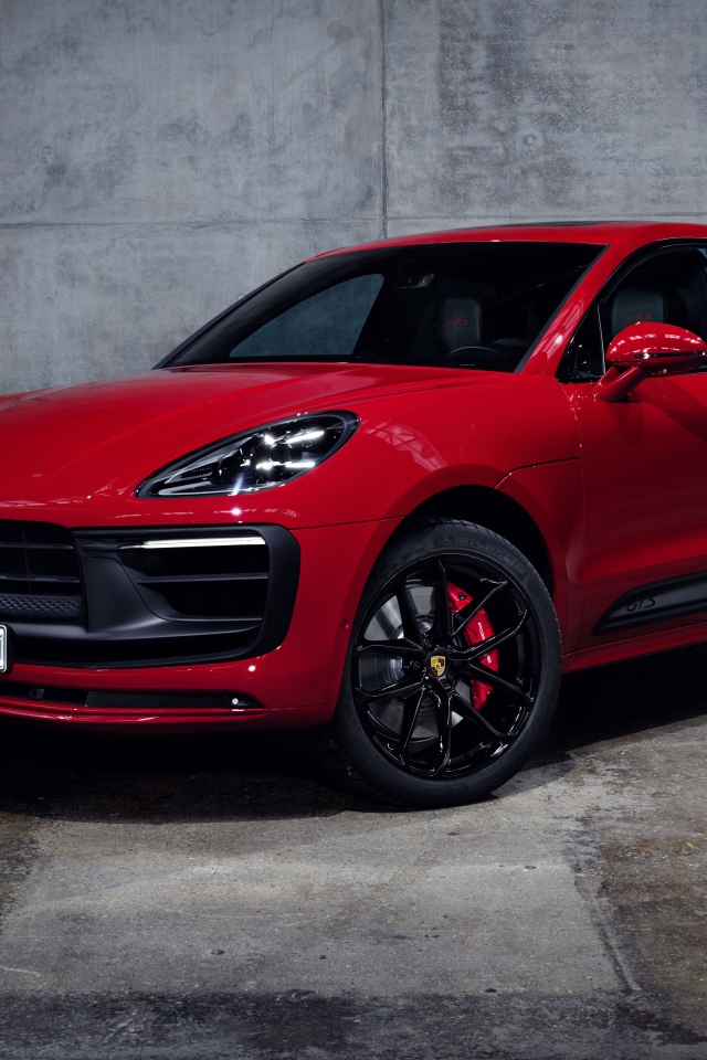 Красный автомобиль Porsche Macan GTS 2021 года на сером фоне