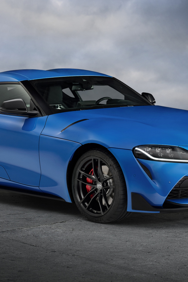 Синий автомобиль Toyota GR Supra, 2021 года на сером фоне