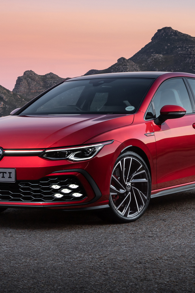Красный Volkswagen Golf GTI 2021 года на фоне гор