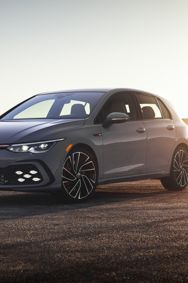 Серебристый автомобиль Volkswagen Golf GTI на фоне заката