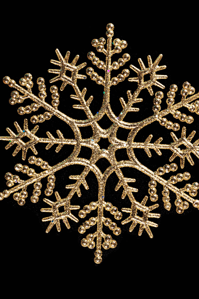 Красивая золотистая снежинка на черном фоне