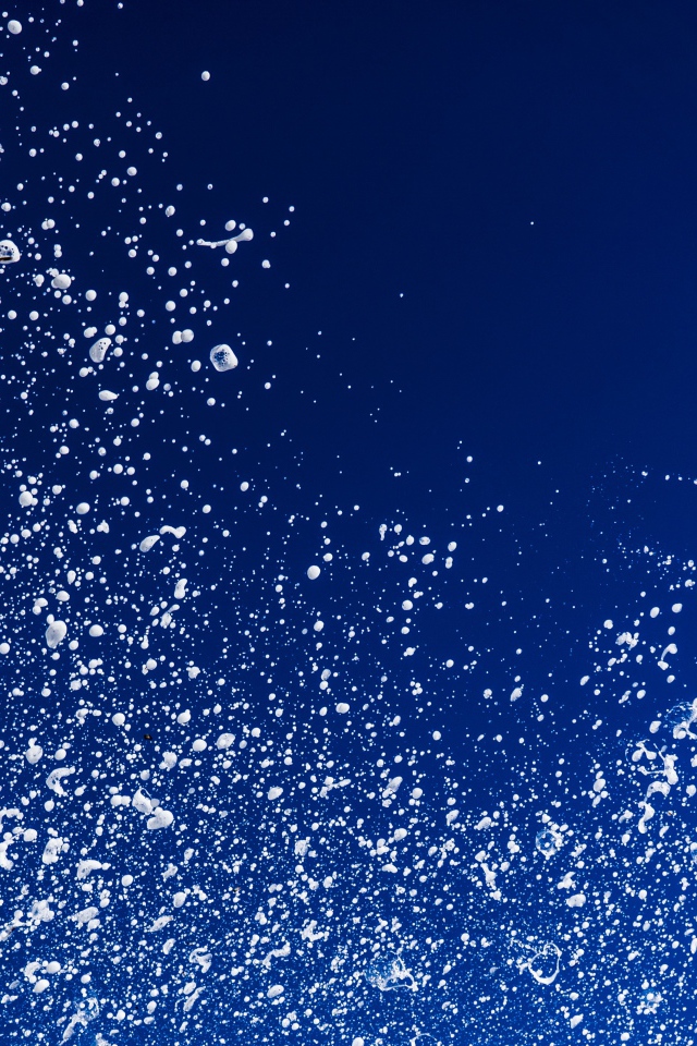 Белые брызги воды на синем фоне 