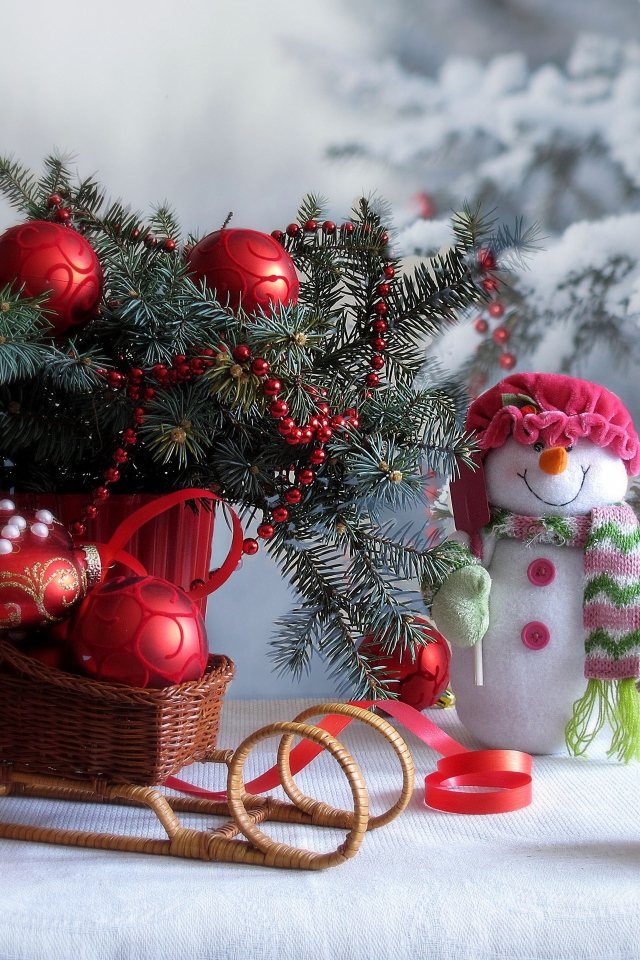 Еловая ветка украшена красным декором к Рождеству 