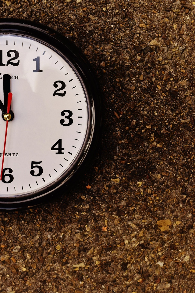 Большие черные часы висят на стене 