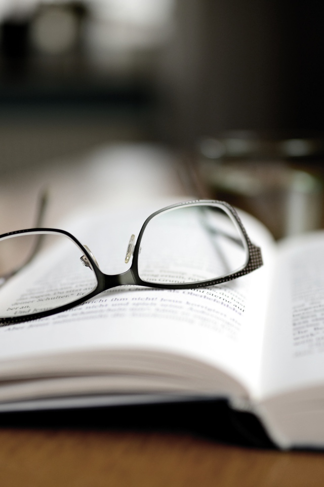 Черные очки лежат на книге 