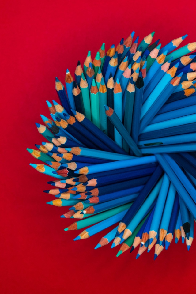 Синие карандаши на красном фоне