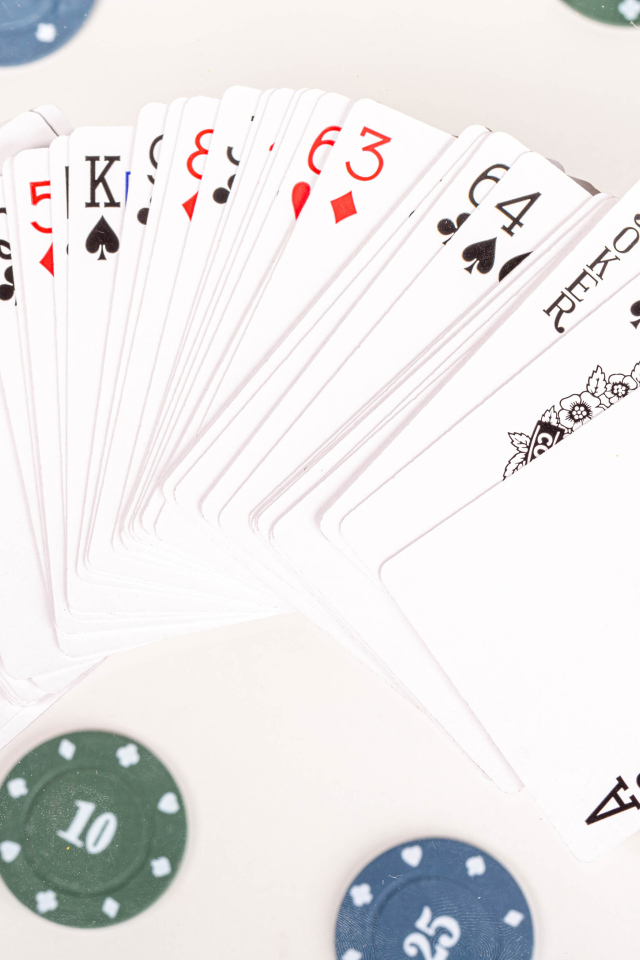 Колода игральных карт и фишки на столе в казино 