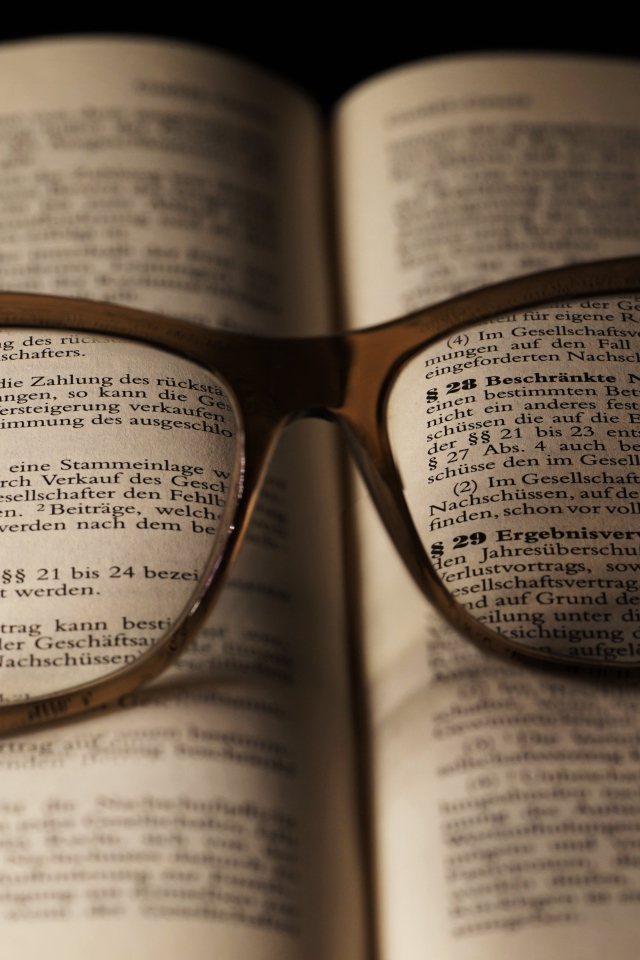 Очки для зрения лежат на открытой книге