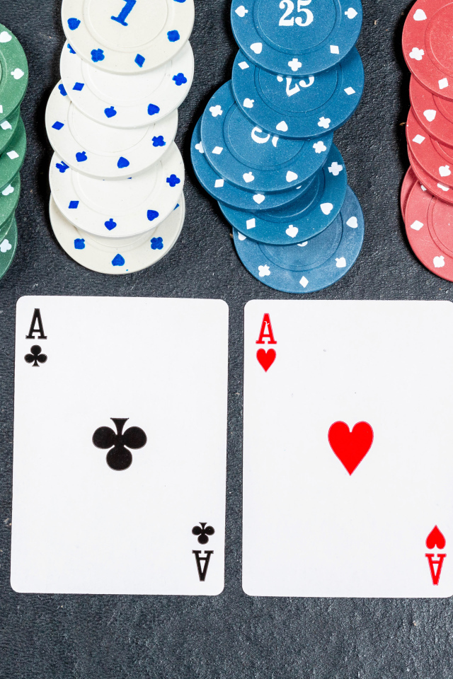 Четыре туза с фишками на сером столе