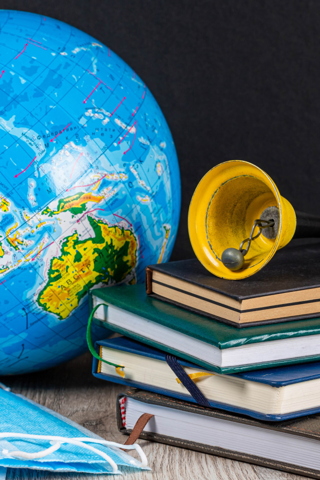 Глобус, книги, колокольчик и медицинские маски 