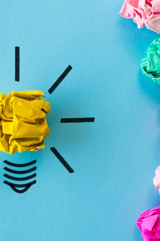 Комки разноцветной бумаги на голубом фоне 