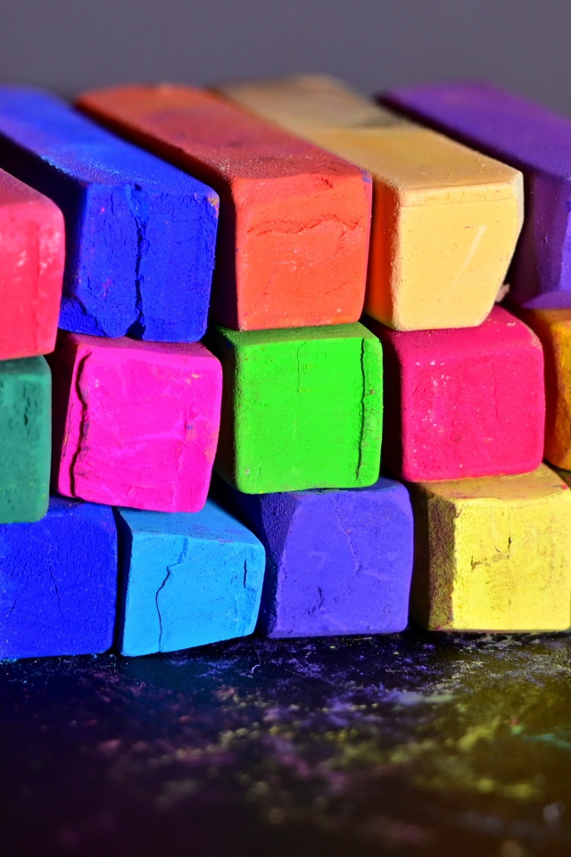 Разноцветные мелки для школы на черной поверхности 