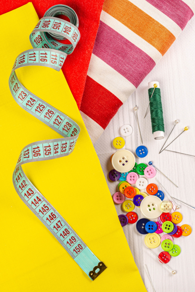 Разноцветная бумага и набор для шитья на столе 