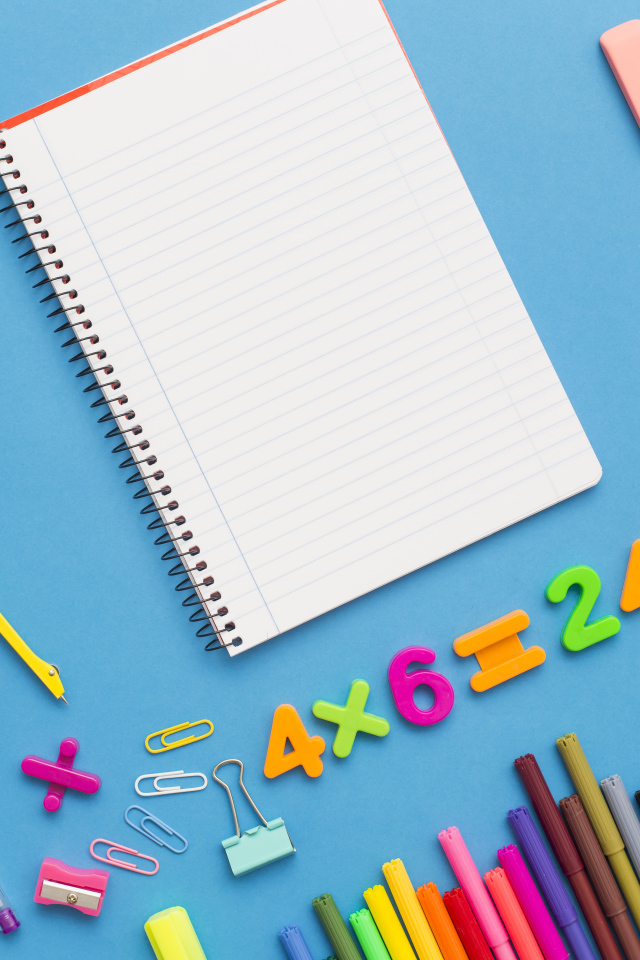 Тетрадь с канцелярскими предметами на голубом фоне 