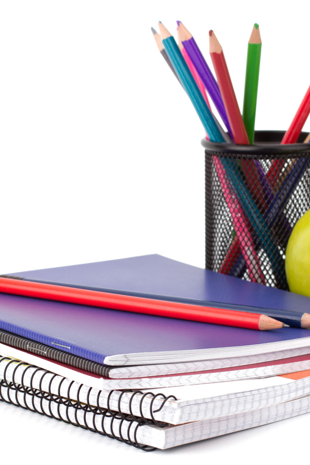 Тетради, яблоко и карандаши на белом фоне 