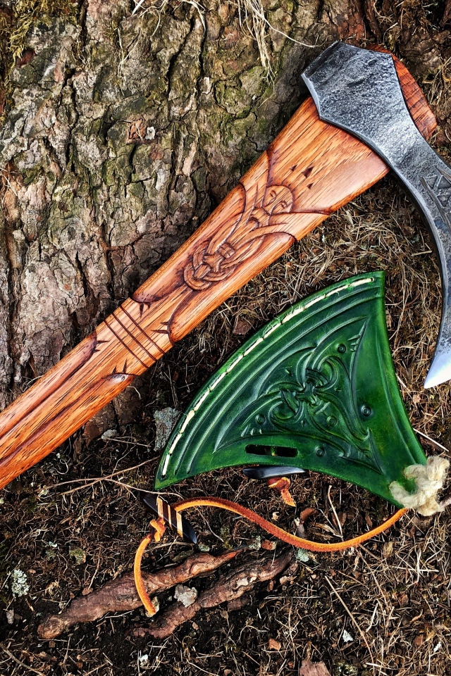 Старый топор с рисунком у дерева 