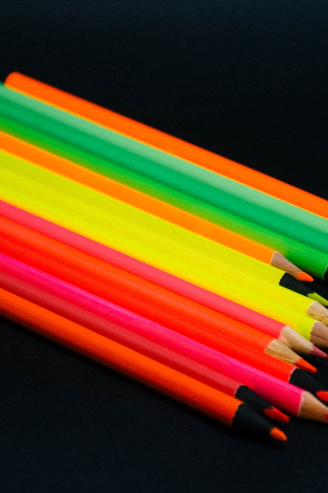 Палитра разноцветных карандашей на черном фоне