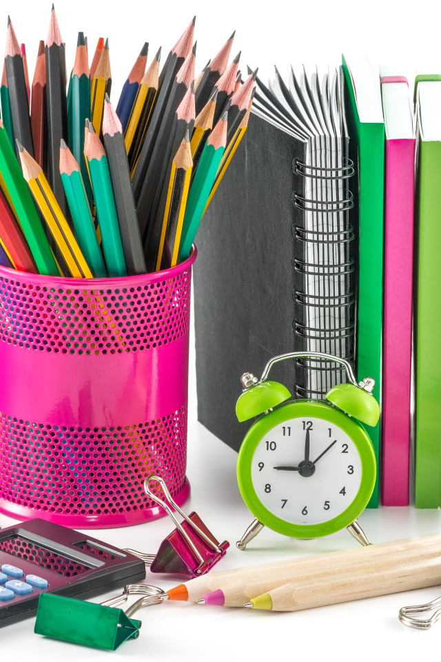 Карандаши, блокноты, часы и яблоко на белом фоне