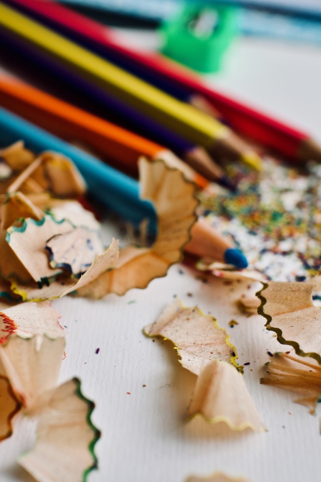 Карандаши со стружкой на сером столе 