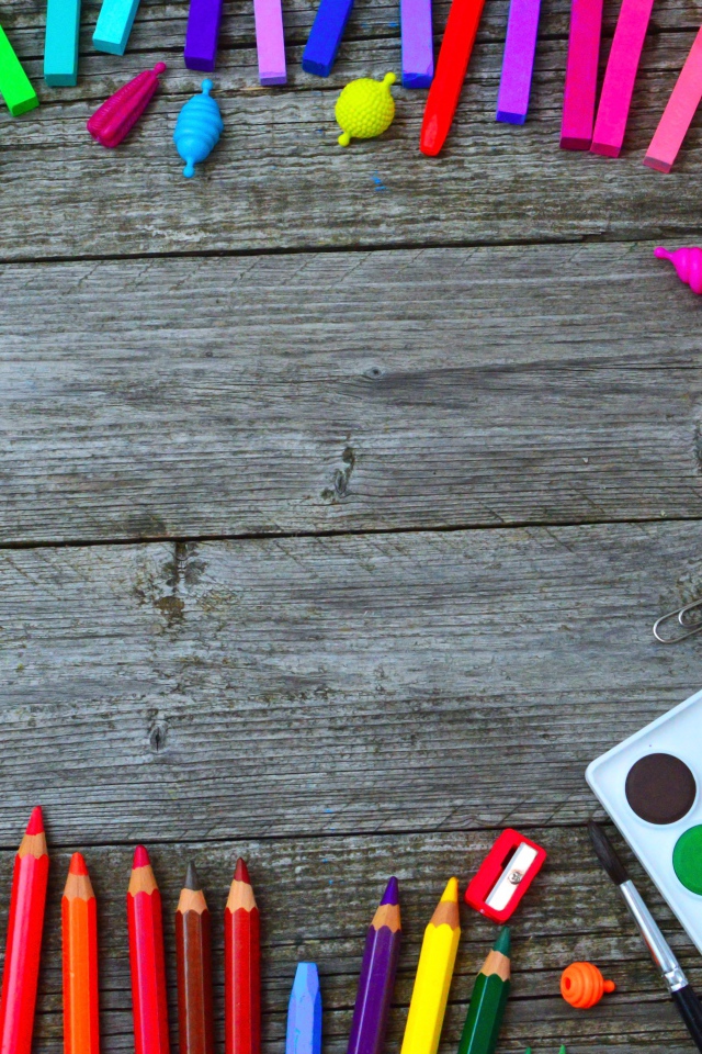 Радуга ярких канцелярских предметов для школы  на деревянном столе