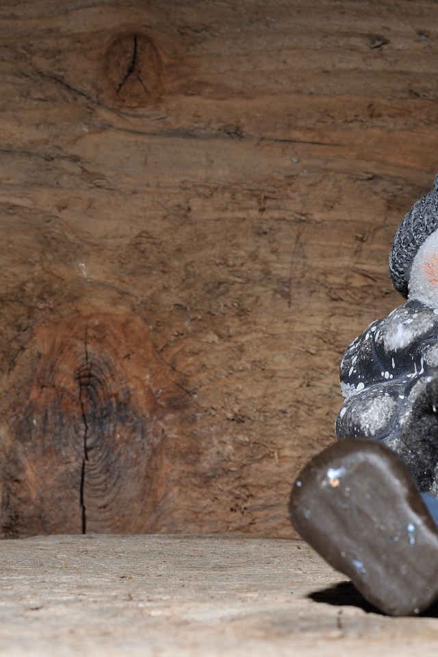 Фигурка снеговик у деревянной стены