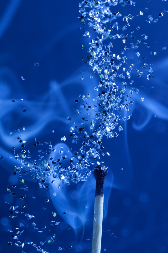 Спичка с блестками на голубом фоне