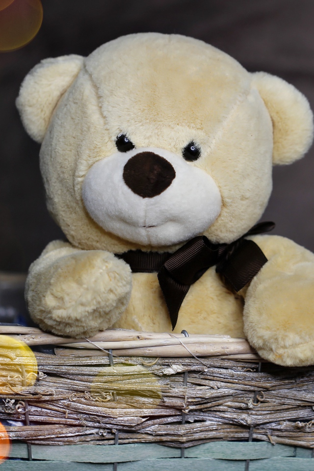 Плюшевый медведь сидит в корзине