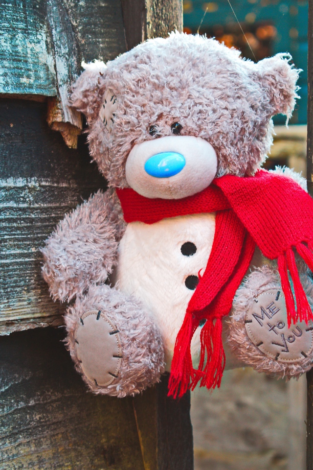 Медвежонок Тедди с красным бантом на заборе 