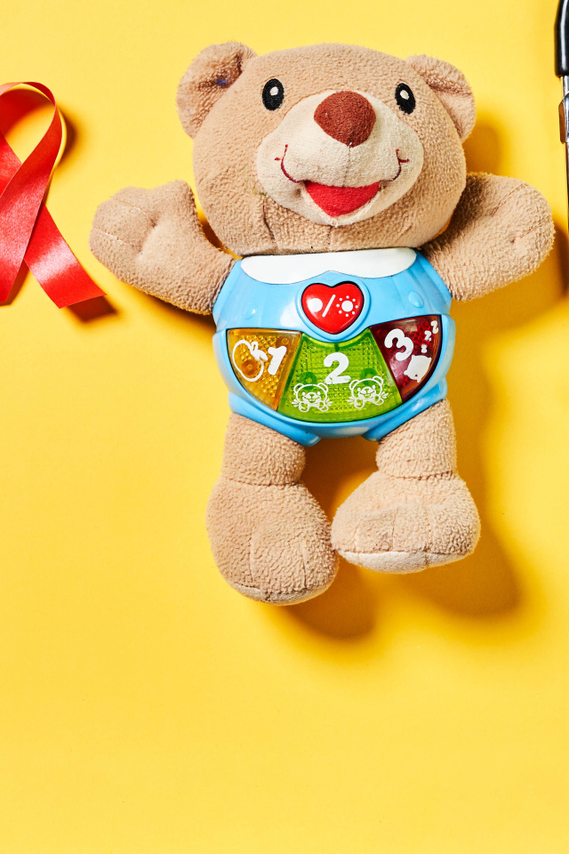 Игрушечный медвежонок с фонендоскопом на желтом фоне 