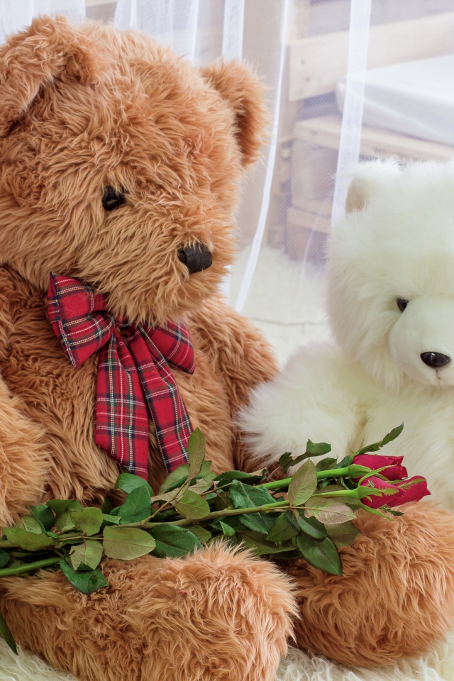 Два больших игрушечных медведя с букетом роз