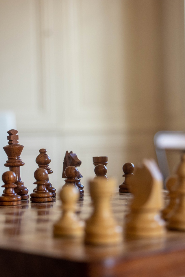 Деревянные шахматы на доске у окна