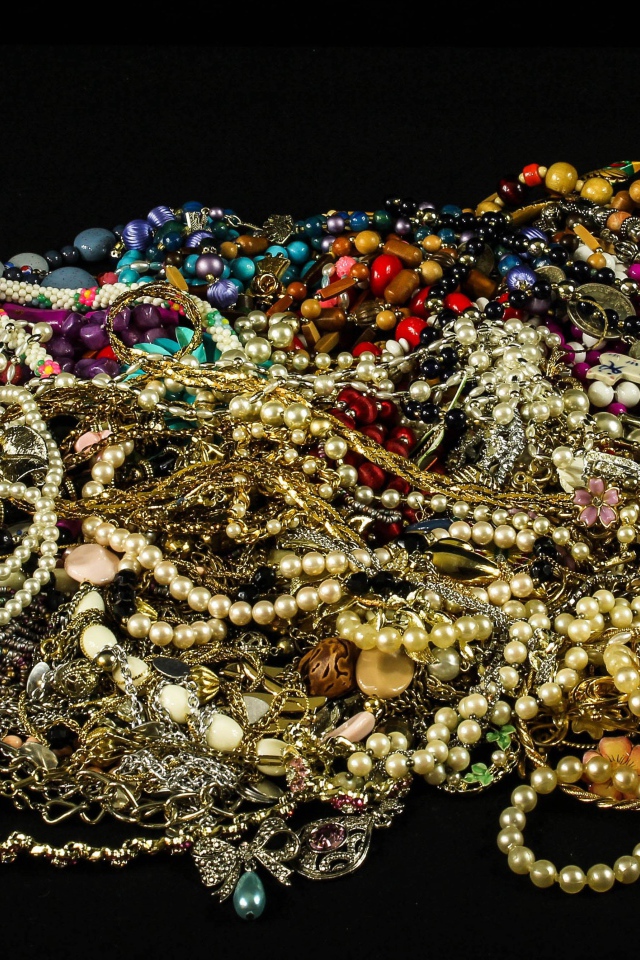 Много драгоценных ювелирных украшений на черном фоне