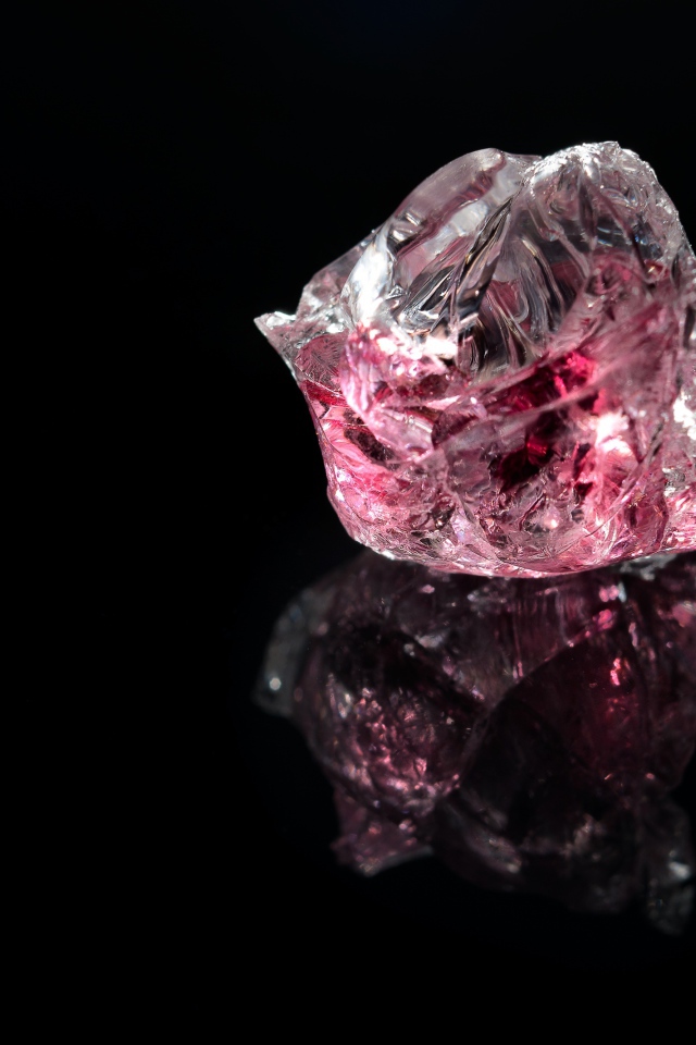 Розовый драгоценный камень на черном фоне 