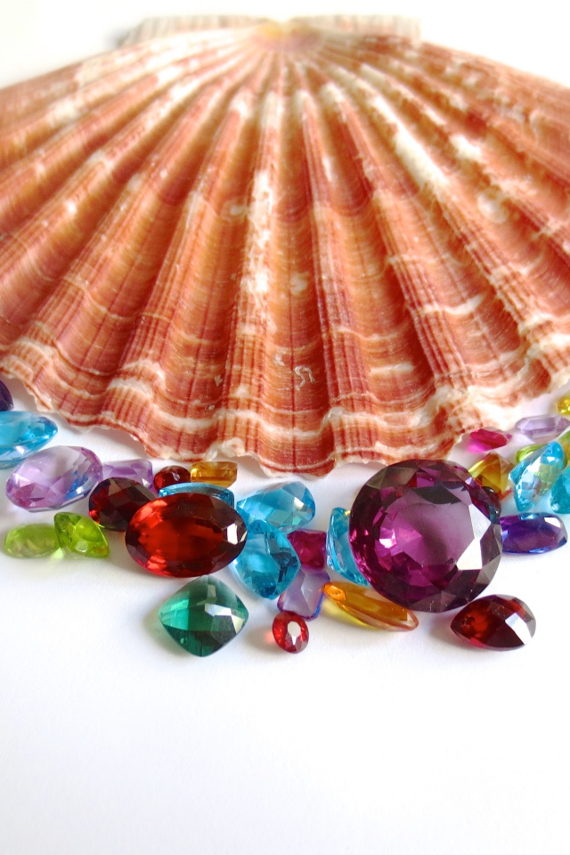 Ракушка и драгоценные камни на белом фоне