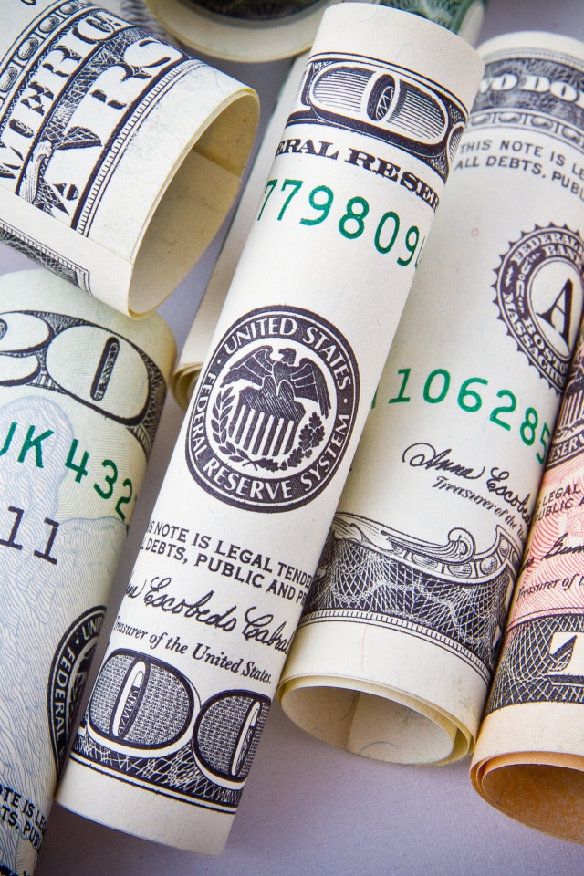 Доллары скрученные в трубочку на столе