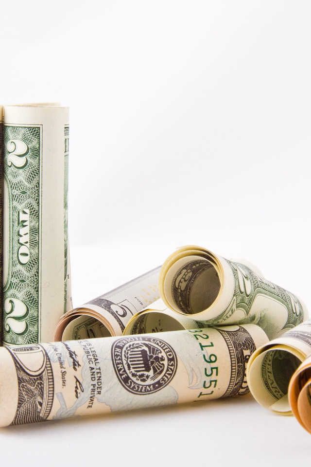 Скрученные в трубочки доллары на белом фоне 