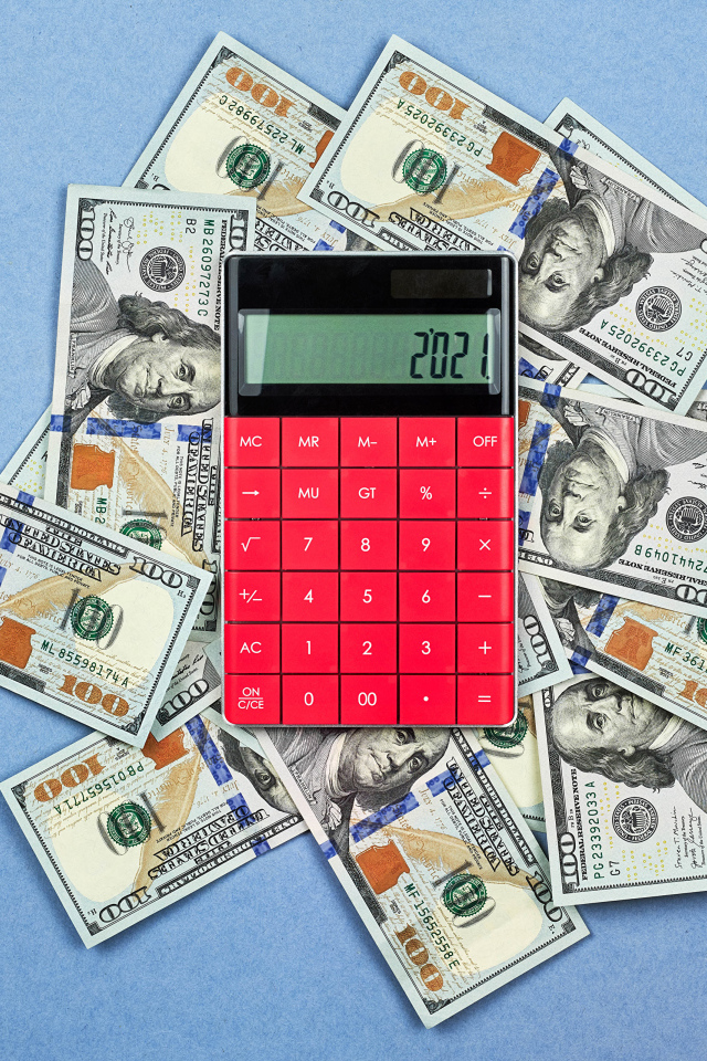 Много долларов с калькулятором на синем фоне
