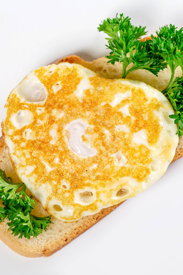 Кусок хлеба с яичницей и петрушкой