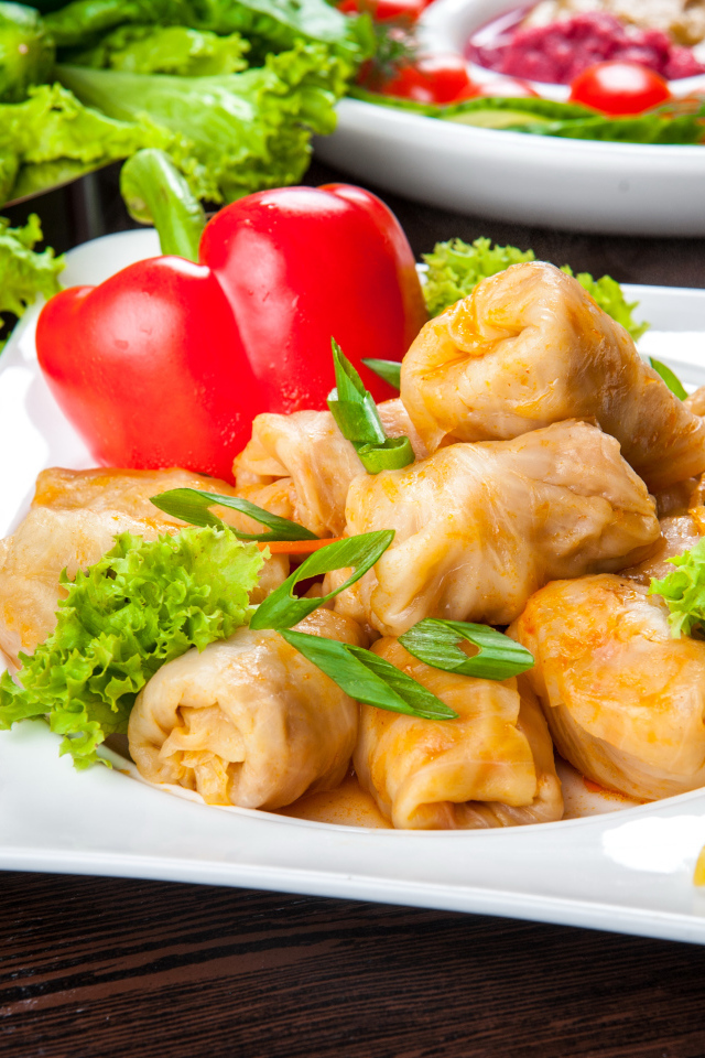 Аппетитные голубцы на тарелке с перцем 