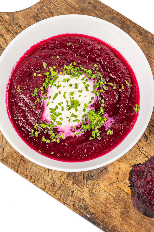 Свекольный суп в тарелке на белом фоне