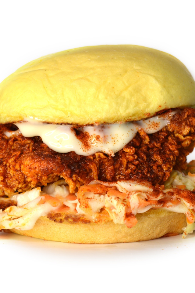 Большой куриный бургер с соусом на белом фоне