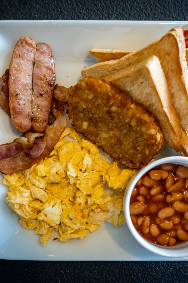 Завтрак на белой тарелке на черном столе 