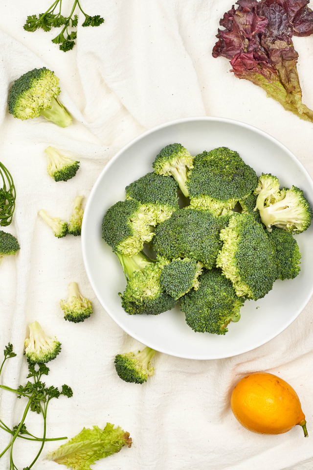 Брокколи на столе с помидорами и зеленью