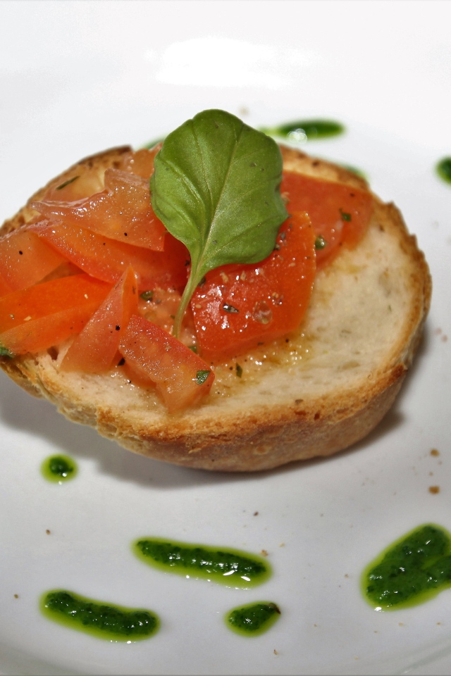 Брускетта на тарелке с помидорами и соусом