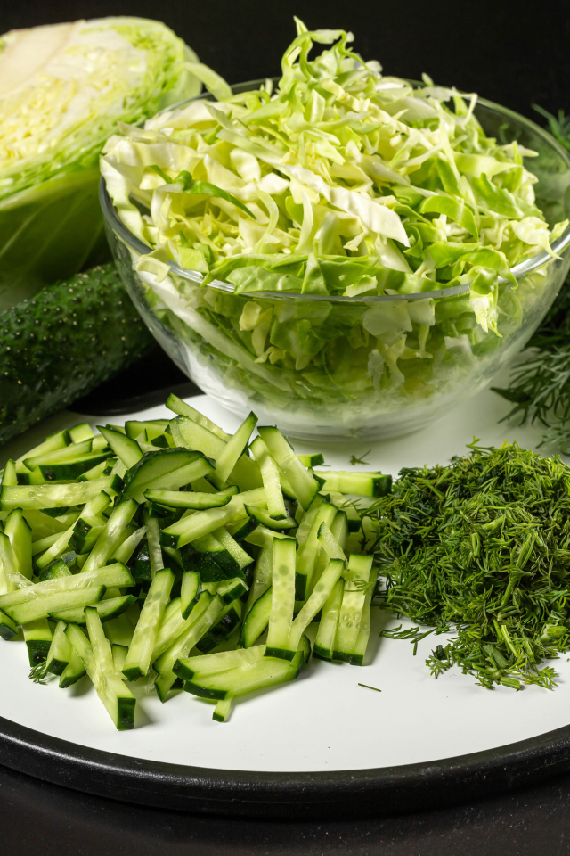 Салат с капусты на столе с огурцами и укропом 