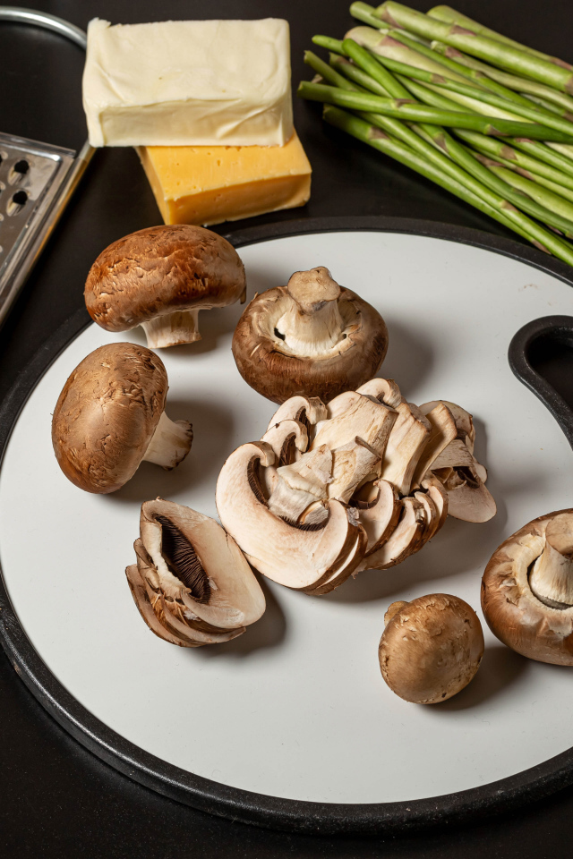 Шампиньоны на столе со спаржей и помидорами 