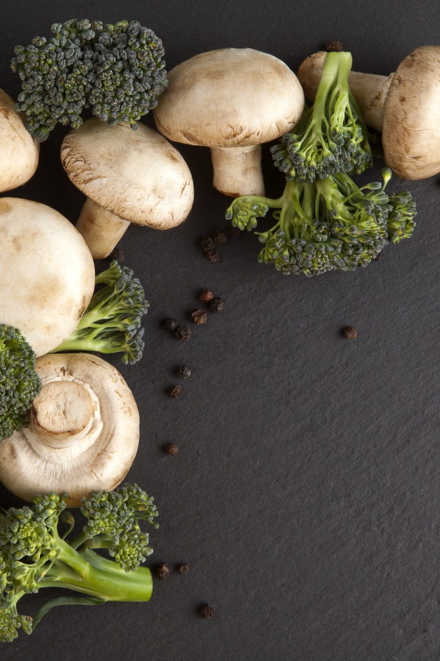 Шампиньоны с брокколи на сером столе 